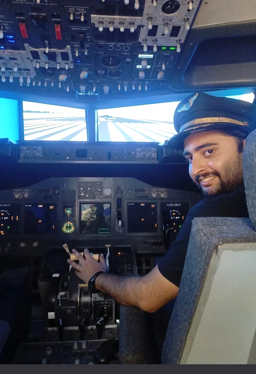 Aditya Sarin seated in a flight simulator, turning towards the camera